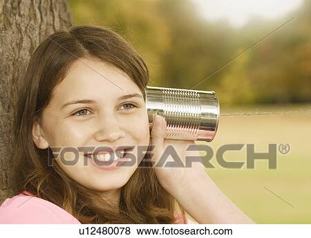 Stock Photo - Girl Listening to Tin Can Phone. Fotosearch