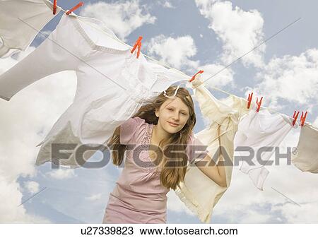 Girl looking through a washing line View Large Photo Image Stock Image - Girl looking through a washing line. Fotosearch