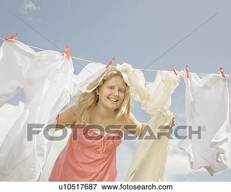 Girl looking through a washing line View Large Photo Image Stock Photo - Girl looking through a washing line. Fotosearch