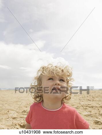 Girl looking upwards on beach View Large Photo Image Stock Photo - Girl looking upwards on beach. Fotosearch