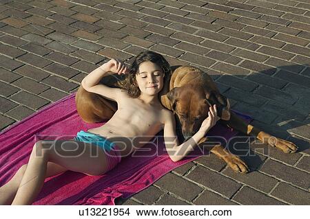 Picture - Girl lying on dog. Fotosearch