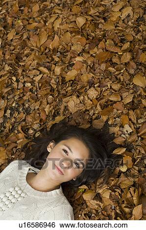 girl lying on leaves View Large Photo Image Stock Photograph - girl lying on leaves. Fotosearch