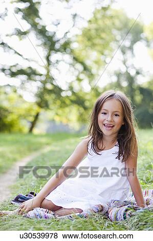 Stock Photo - girl on blanket smiling at viewer. Fotosearch