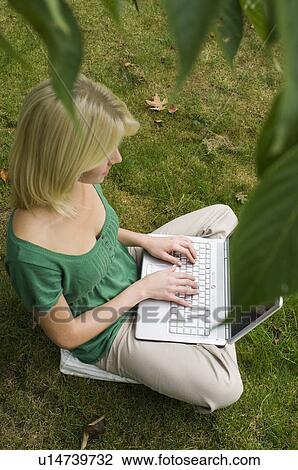 Stock Image - girl on computer in garden. Fotosearch
