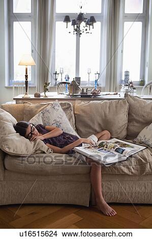 Picture - girl on couch fallen asleep. Fotosearch