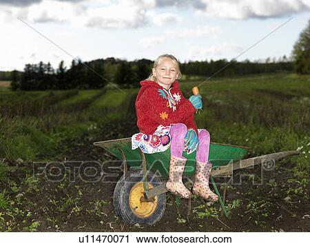 Girl on wheelbarrow View Large Photo Image Stock Image - Girl on wheelbarrow. Fotosearch