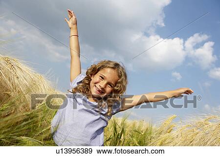 Girl playing in a wheat field View Large Photo Image Stock Photo - Girl playing in a wheat field. Fotosearch