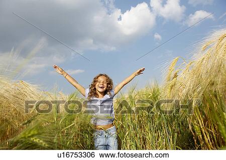 Stock Photograph - Girl playing in a wheat field. Fotosearch
