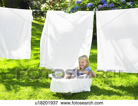 Girl playing in the laundry basket View Large Photo Image Stock Photo - Girl playing in the laundry basket. Fotosearch