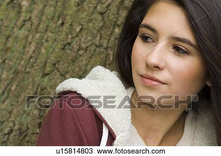 Stock Image - girl portrait against tree. Fotosearch