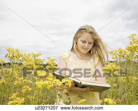 Stock Photo - Girl reading book in field. Fotosearch
