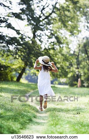Stock Image - girl running down a path. Fotosearch
