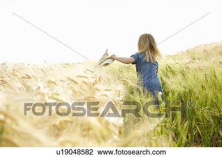 Girl running in a wheat field View Large Photo Image Stock Image - Girl running in a wheat field. Fotosearch
