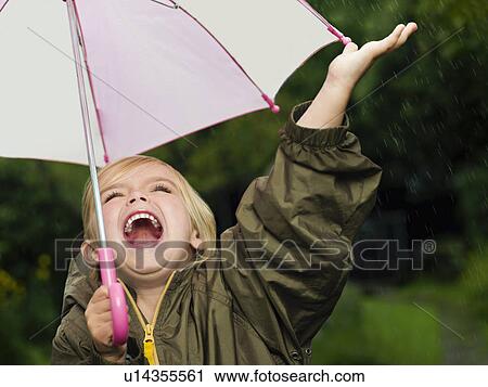 Stock Image - Girl singling holding an umbrella. Fotosearch