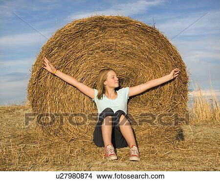 girl sitting in front of hay bale View Large Photo Image Picture - girl sitting in front of hay bale. Fotosearch