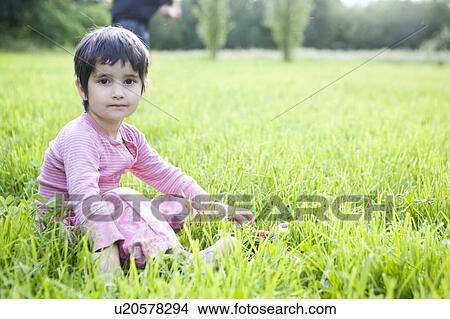 Girl sitting in grass View Large Photo Image Picture - Girl sitting in grass. Fotosearch