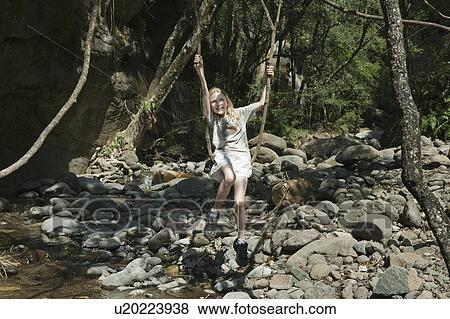 Girl sitting on tree root swing View Large Photo Image Stock Photo - Girl sitting on tree root swing. Fotosearch