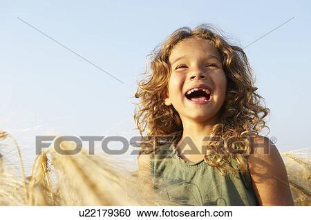 Girl smiling in a wheat field View Large Photo Image Stock Image - Girl smiling in a wheat field. Fotosearch