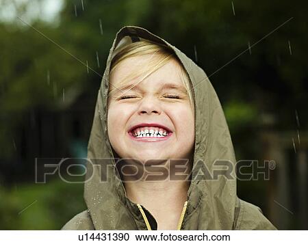 Stock Image - Girl smiling while it rains. Fotosearch
