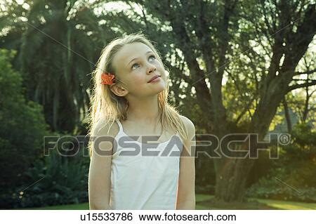 Stock Photograph - Girl standing in garden. Fotosearch