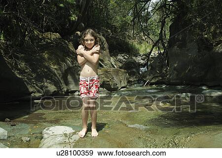 Stock Photo - Girl standing on rock in stream. Fotosearch