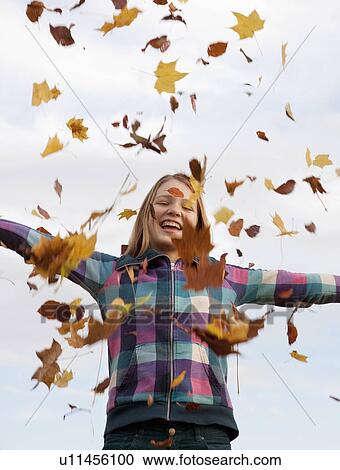 girl throwing autumn leaves into the air View Large Photo Image Stock Image - girl throwing autumn leaves into the air. Fotosearch