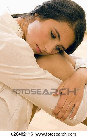 Stock Photograph - girl with arms around legs. Fotosearch
