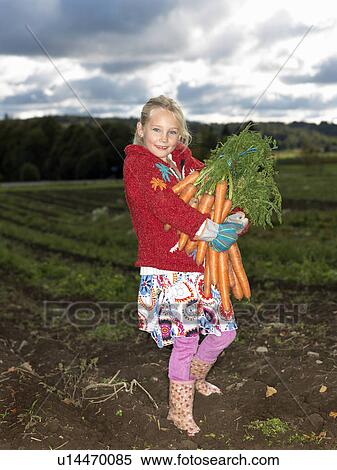 Stock Photography - Girl with bunch of carrots. Fotosearch