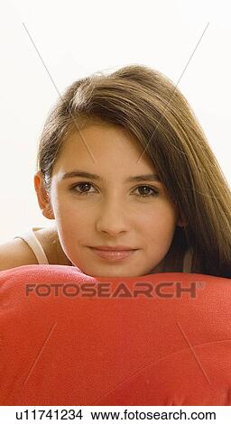 Picture - girl with chin on cushion. Fotosearch