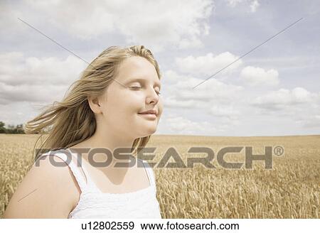 Girl with eyes closed in wheat field View Large Photo Image Stock Photo - Girl with eyes closed in wheat field. Fotosearch