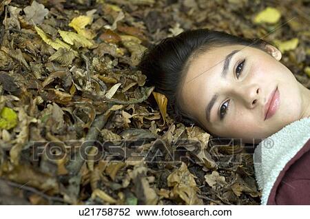 Stock Image - girl with head on leaves. Fotosearch