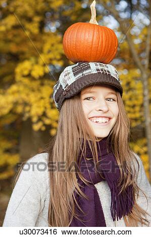 Girl with pumpkin on the head View Large Photo Image Stock Photograph - Girl with pumpkin on the head. Fotosearch