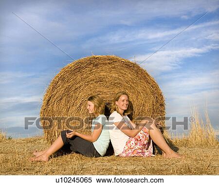 girl, woman sitting in front of hay bale View Large Photo Image Stock Photography - girl, woman sitting in front of hay bale. Fotosearch