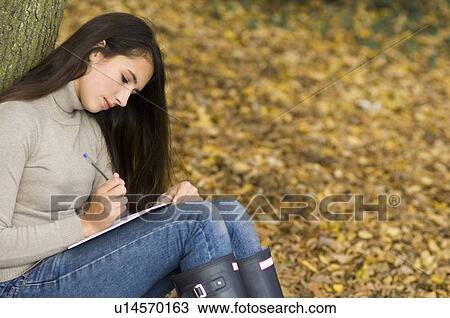 girl writing against a tree View Large Photo Image Stock Image - girl writing against a tree. Fotosearch