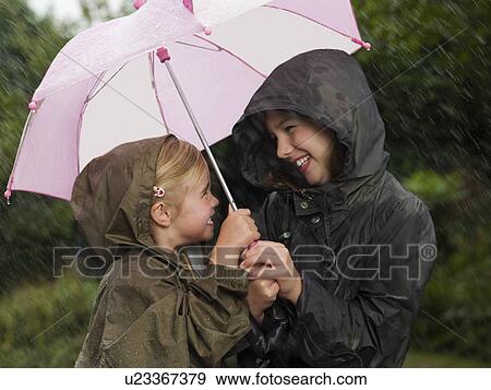 Stock Photo - Girls huddled under an umbrella. Fotosearch