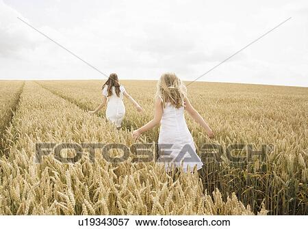 Girls in wheat field View Large Photo Image Stock Photo - Girls in wheat field. Fotosearch