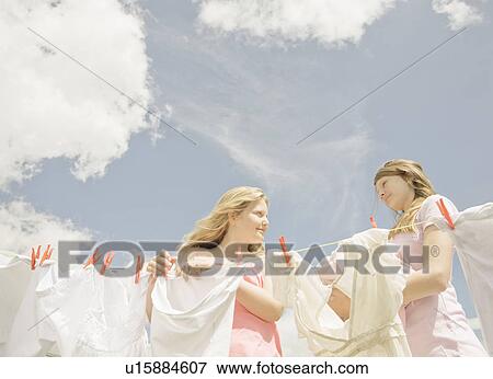 Stock Photo - Girls putting washing on a line. Fotosearch