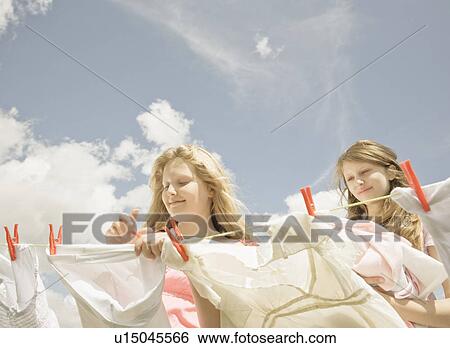 Stock Photograph - Girls putting washing on a line. Fotosearch