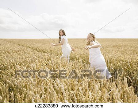 Girls running in wheat field View Large Photo Image Stock Image - Girls running in wheat field. Fotosearch