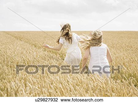 Girls running in wheat field View Large Photo Image Stock Image - Girls running in wheat field. Fotosearch