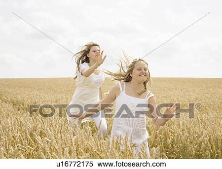 Stock Photography - Girls running in wheat field. Fotosearch