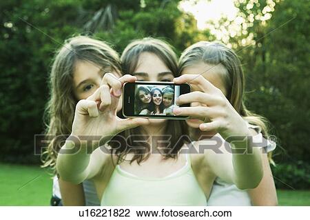 Girls taking photo with mobile phone View Large Photo Image Stock Image - Girls taking photo with mobile phone. Fotosearch