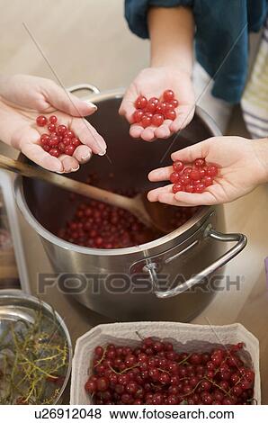 Stock Photo - girls with grandmother cooking jam. Fotosearch