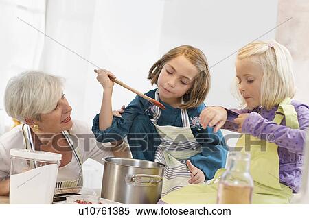 girls with grandmother cooking jam View Large Photo Image Stock Photography - girls with grandmother cooking jam. Fotosearch
