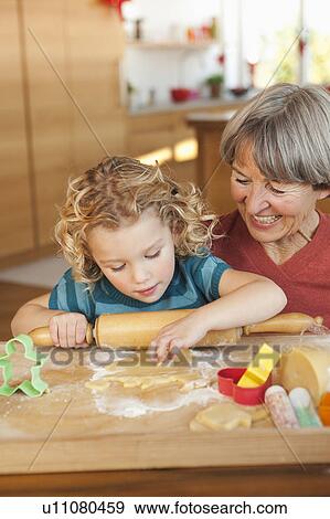 Stock Photo - grandchild and grandma making biscuits. Fotosearch