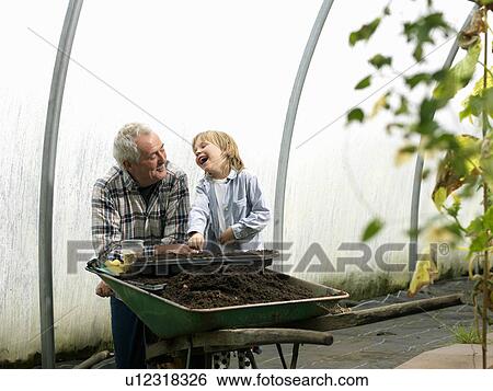 Stock Photograph - Grandfather and boy planting flowers. Fotosearch