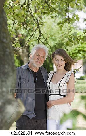 Stock Image - grandfather and granddaughter in garden. Fotosearch