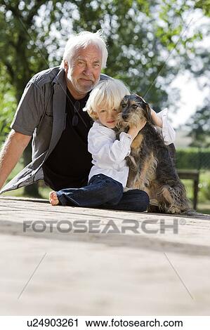 Stock Image - grandfather and grandson with dog. Fotosearch
