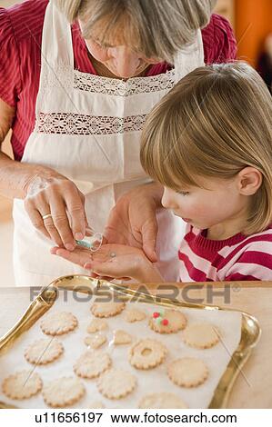 Stock Photo - grandma and grandchild baking biscuits. Fotosearch