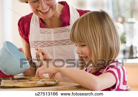 Stock Photograph - grandma and grandchild baking biscuits. Fotosearch